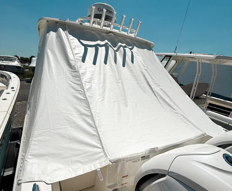 Slide: The Image of 2025 Pursuit DC 326 Dual Console boat with protective cover in marina. - 35