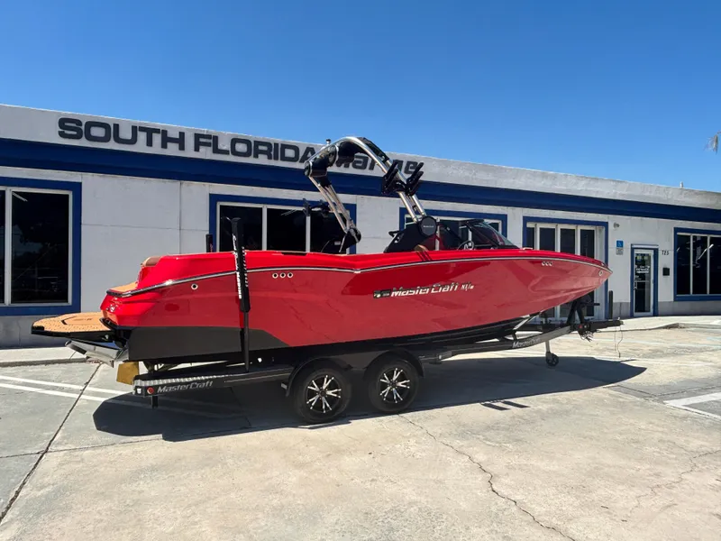 The Image of 2025 MasterCraft NXT24 boat in vibrant red on trailer at South Florida dealership. - 1