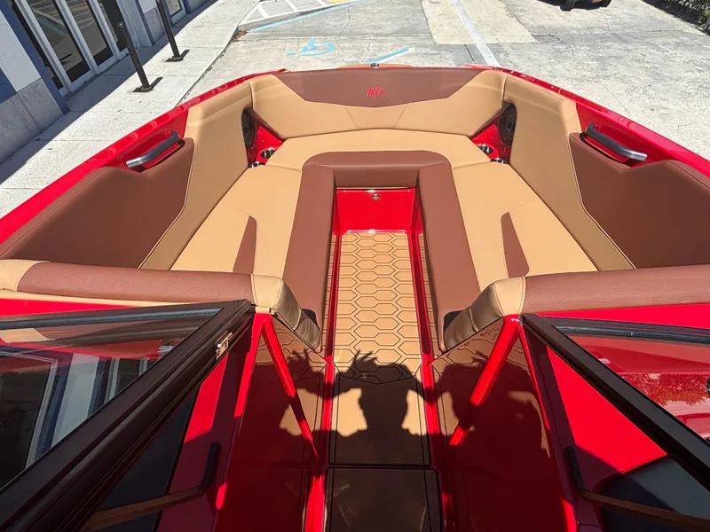Slide: The Image of 2025 MasterCraft NXT24 boat interior with red and tan seating, hexagonal floor pattern. - 11