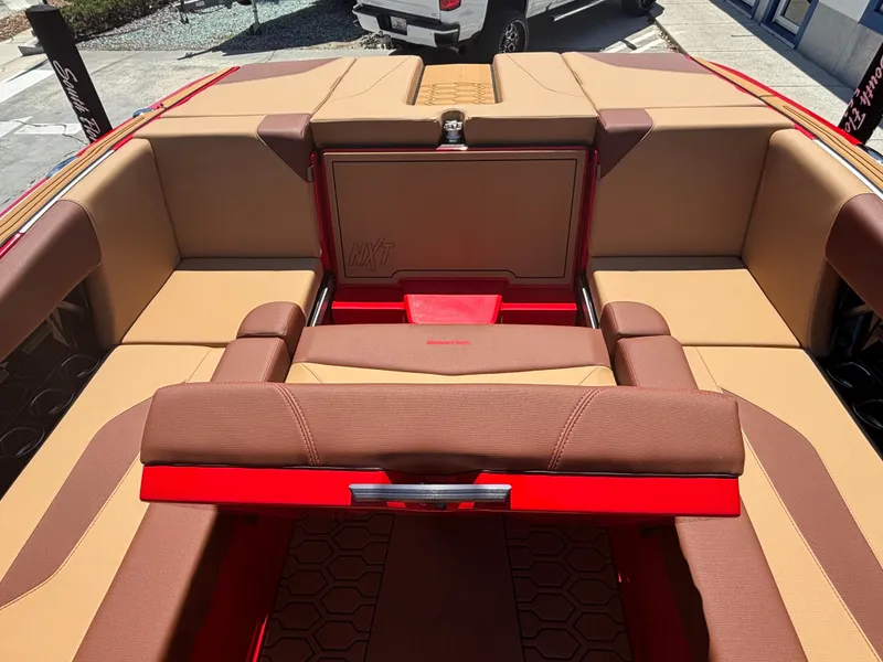 Slide: The Image of 2025 MasterCraft NXT24 boat interior with tan and red seating, showcasing luxury design. - 13