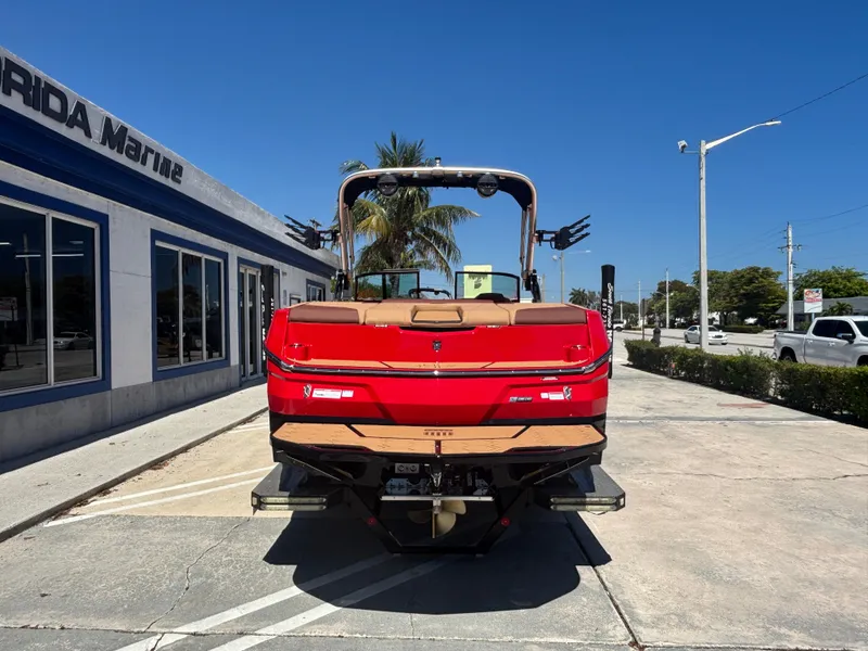 Slide: The Image of 2025 MasterCraft NXT24 boat in red, parked outside a marine dealership. - 3