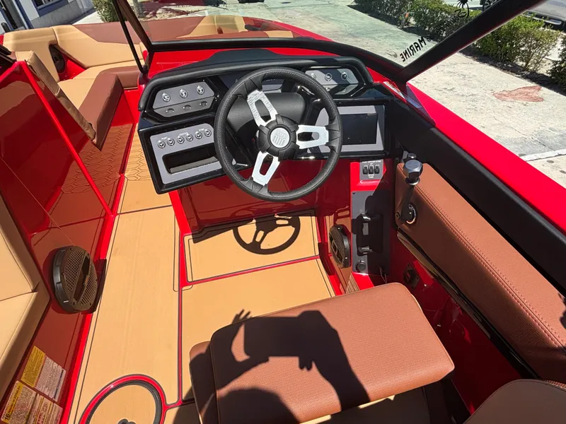 Slide: The Image of 2025 MasterCraft NXT24 boat interior with red and tan design, featuring a modern steering console. - 8