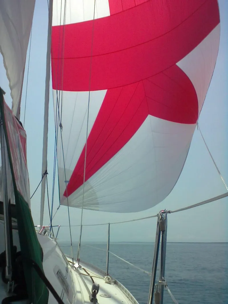 Slide: The Image of Sailing on a 2002 Beneteau 331 with vibrant red and white sails. - 10