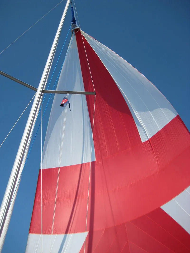 Slide: The Image of Red and white sail of a 2002 Beneteau 331 against a clear blue sky. - 11