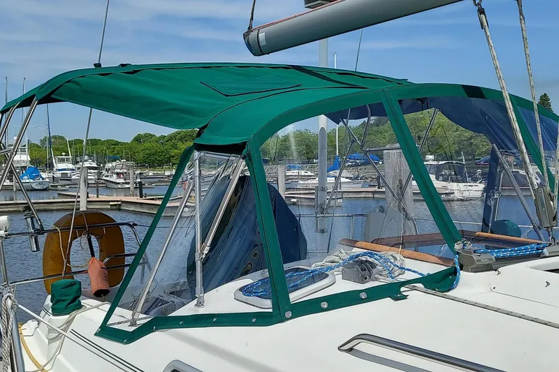Slide: The Image of 2002 Beneteau 331 sailboat with green canopy docked at marina. - 18