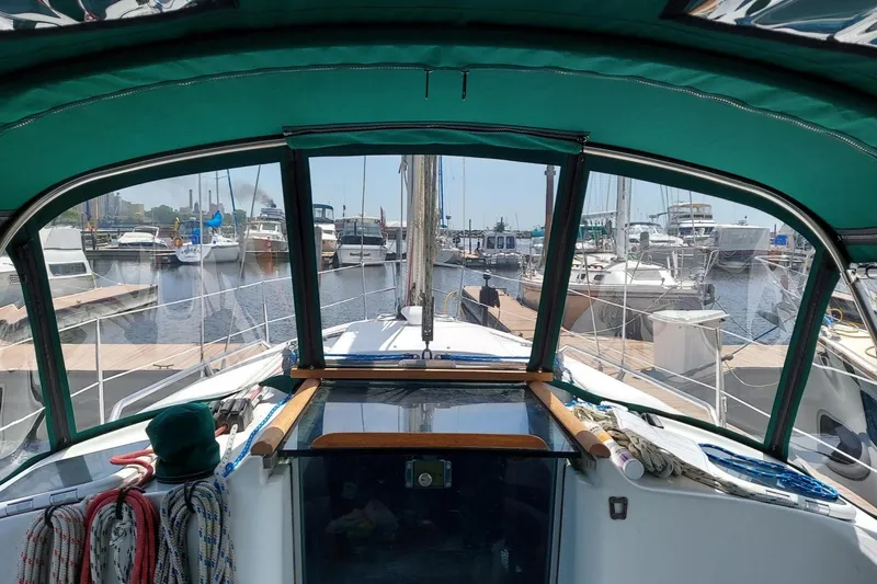 Slide: The Image of Cockpit view of 2002 Beneteau 331 sailboat docked at marina, featuring green canopy. - 19