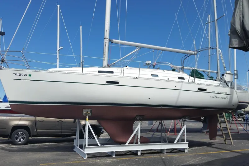 Slide: The Image of 2002 Beneteau 331 sailboat on a stand, displayed outdoors under a clear blue sky. - 2