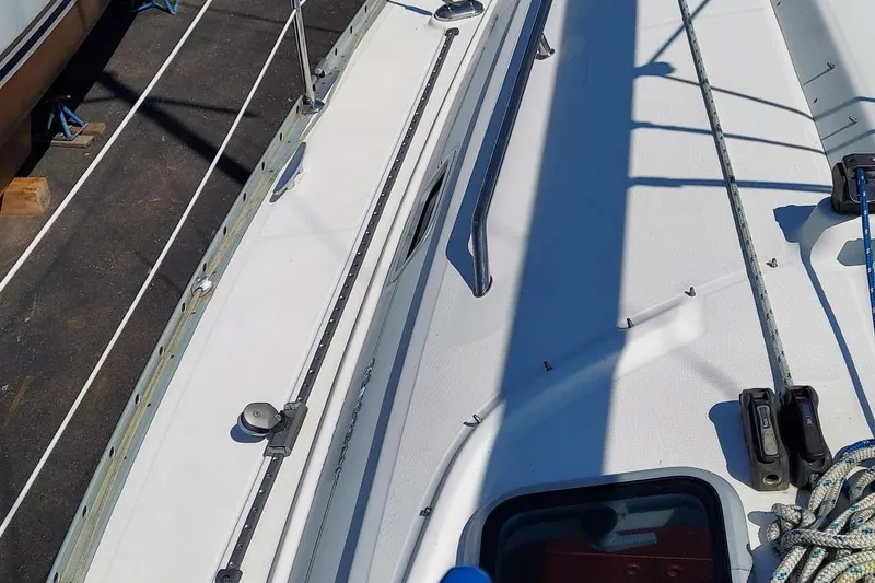 Slide: The Image of 2002 Beneteau 331 sailboat deck with rigging and hatch, docked in sunlight. - 22