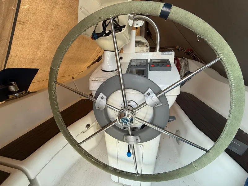 Slide: The Image of Steering wheel of a 2002 Beneteau 331 sailboat, featuring navigation controls. - 25