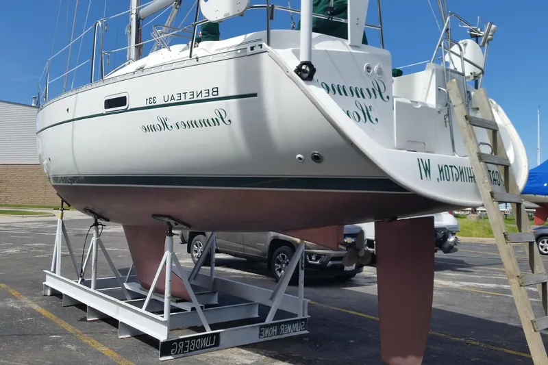 Slide: The Image of 2002 Beneteau 331 sailboat on a stand in a parking lot, viewed from the side. - 3