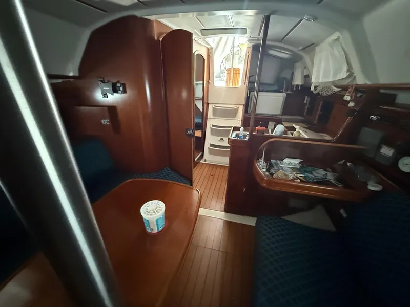 Slide: The Image of Interior of 2002 Beneteau 331 sailboat with wooden furnishings and cozy seating area. - 35