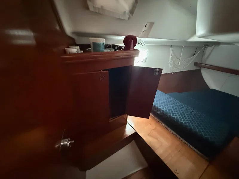 Slide: The Image of Cozy cabin interior of 2002 Beneteau 331 sailboat with wooden cabinetry and bed. - 36