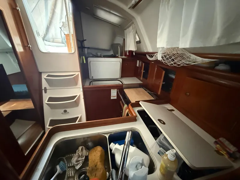 Slide: The Image of Interior of a 2002 Beneteau 331 sailboat, featuring a compact kitchen area. - 38
