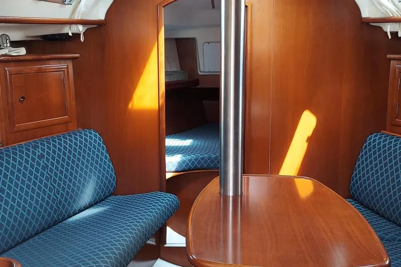 Slide: The Image of Interior of 2002 Beneteau 331 sailboat with wooden furnishings and blue seating. - 46