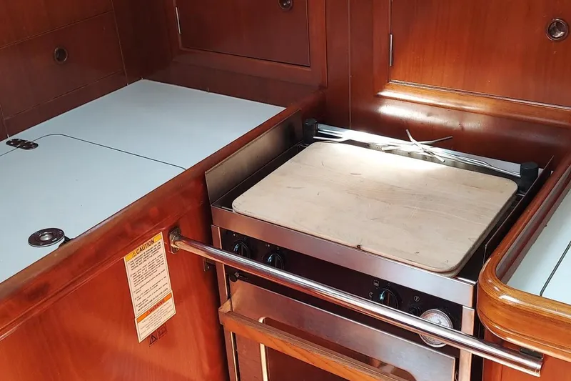 Slide: The Image of Galley kitchen in 2002 Beneteau 331 sailboat with stove and wooden countertop. - 47