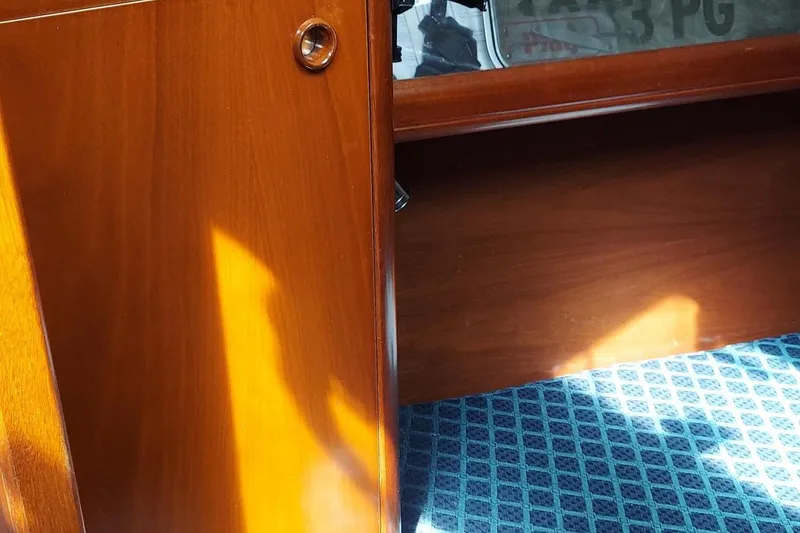 Slide: The Image of Interior of a 2002 Beneteau 331 sailboat with wooden cabinetry and patterned flooring. - 48