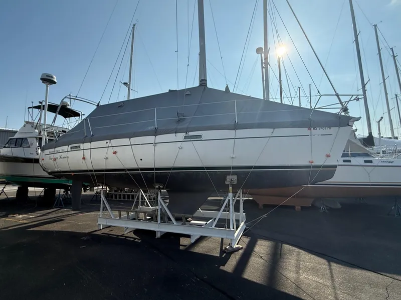 Slide: The Image of 2002 Beneteau 331 sailboat on dry dock, covered and secured, with masts visible. - 6