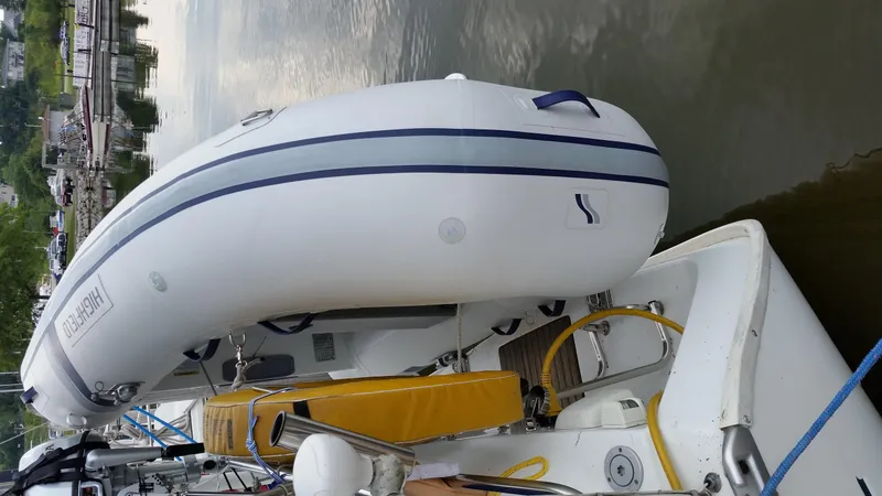 Slide: The Image of 2002 Beneteau 331 sailboat with inflatable dinghy docked on calm water. - 66