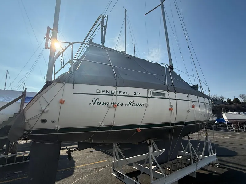Slide: The Image of 2002 Beneteau 331 sailboat named "Summer Home" on a stand, sunlit background. - 7