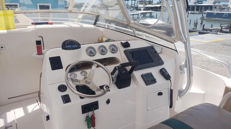 Slide: The Image of 2005 Intrepid 310 Walkaround boat helm with steering wheel, gauges, and navigation equipment. - 2
