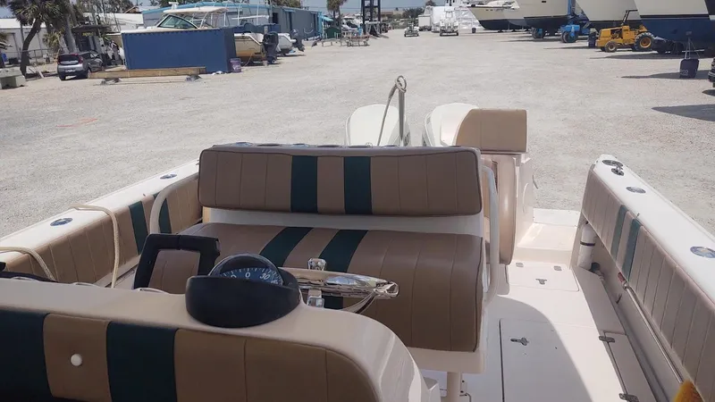 Slide: The Image of 2005 Intrepid 310 Walkaround boat interior with striped seating in a marina setting. - 4