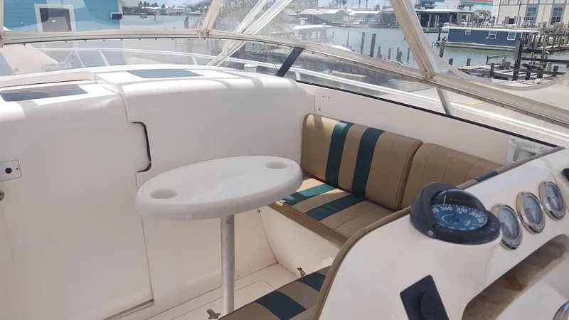Slide: The Image of 2005 Intrepid 310 Walkaround boat interior with seating and table, dockside view. - 5