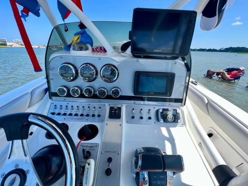 Slide: The Image of 2017 Concept 30CC boat dashboard with gauges and Garmin displays on a sunny day. - 2