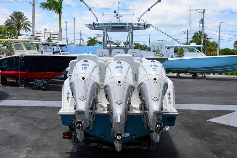 Slide: The Image of 2022 Contender 35 ST boat with triple outboard engines, parked in a marina. - 10