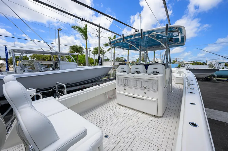 Slide: The Image of 2022 Contender 35 ST boat with spacious deck and seating, docked under a clear blue sky. - 38