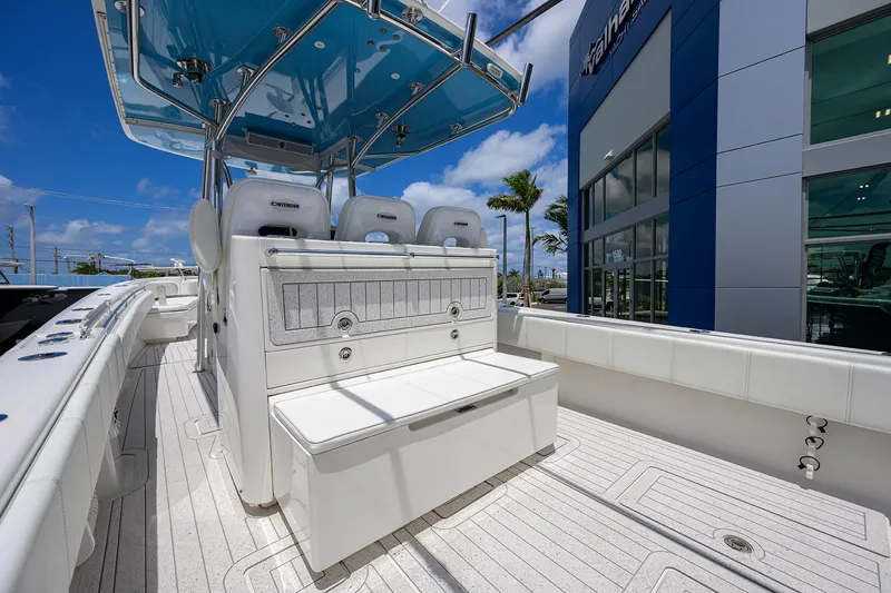 Slide: The Image of 2022 Contender 35 ST boat interior with seating, under a blue sky near a dealership. - 40