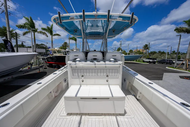 Slide: The Image of 2022 Contender 35 ST boat interior with seating, under a blue sky and palm trees. - 41
