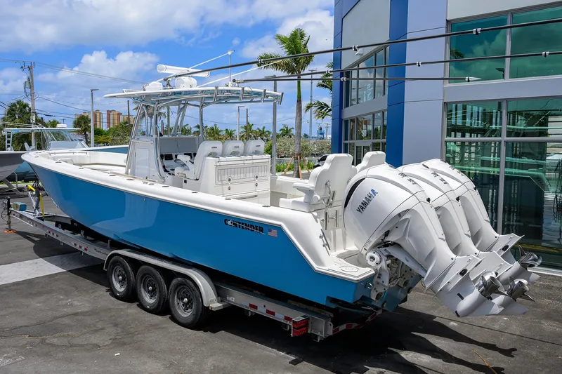 Slide: The Image of 2022 Contender 35 ST boat with triple Yamaha engines on a trailer, parked outdoors. - 6