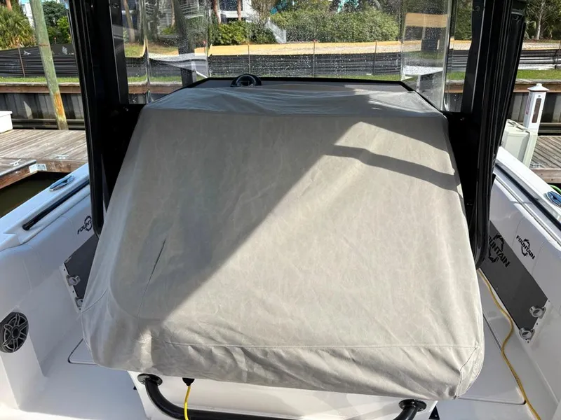 Slide: The Image of 2024 Fountain 34 TE boat console covered with protective fabric at a marina. - 12
