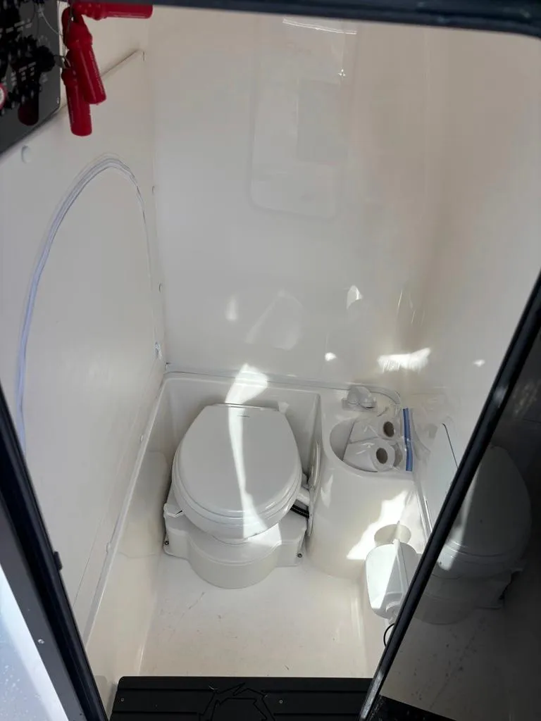 Slide: The Image of 2024 Fountain 34 TE boat interior with compact marine toilet and storage. - 8