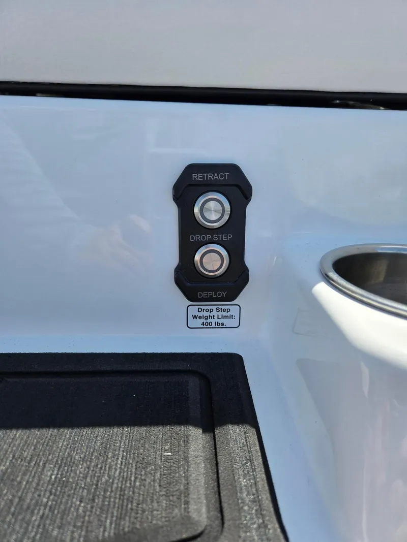 Slide: The Image of 2025 Moomba Craz boat drop step controls with retract and deploy buttons, 400 lbs weight limit. - 15
