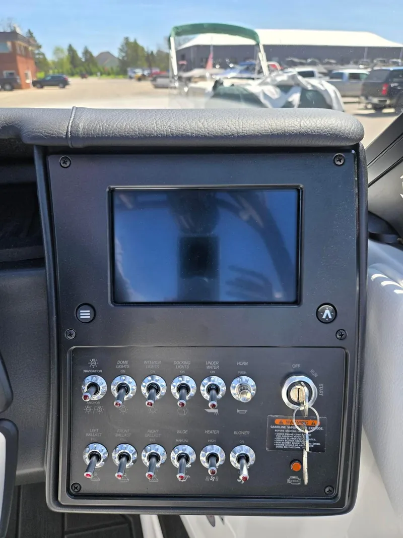 Slide: The Image of Control panel of a 2025 Moomba Craz boat with switches and a display screen. - 25