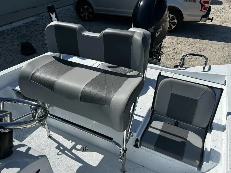 Slide: The Image of 2025 Xpress H20B boat interior with gray seating and steering wheel. - 11
