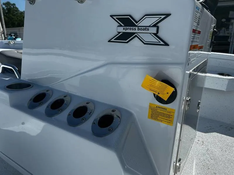 Slide: The Image of 2025 Xpress H20B boat console with rod holders and logo in sunlight. - 13