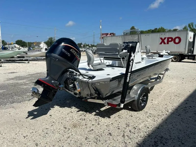 Slide: The Image of 2025 Xpress H20B boat with outboard motor on a trailer in a sunny lot. - 7