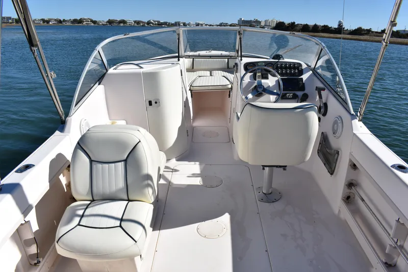 Slide: The Image of 2005 Grady-White 205 boat interior with steering wheel and seating on calm water. - 6