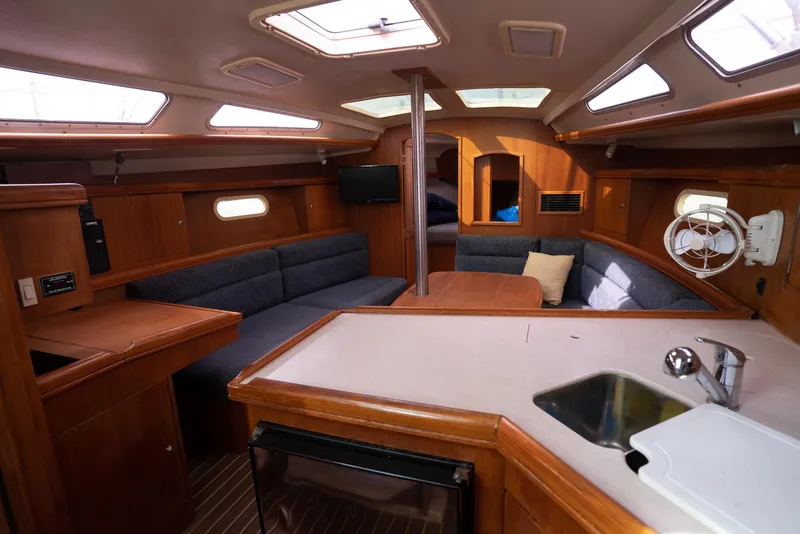 Slide: The Image of Interior of a 2004 Hunter 36 sailboat with wood finish and seating area. - 18