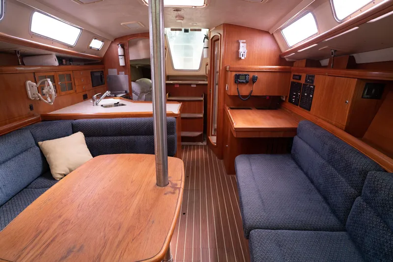 Slide: The Image of Interior of a 2004 Hunter 36 sailboat with wooden furnishings and blue seating. - 19