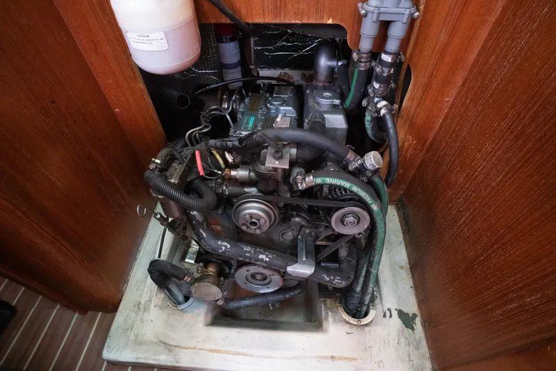 Slide: The Image of Engine compartment of a 2004 Hunter 36 sailboat, featuring visible hoses and components. - 25