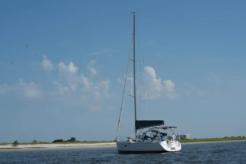 Slide: The Image of 2004 Hunter 36 sailboat on calm water under a clear blue sky. - 26