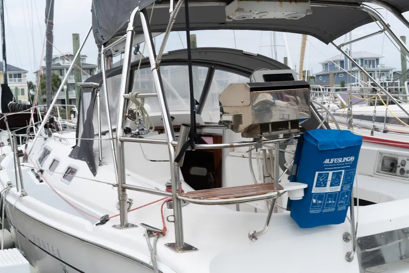 Slide: The Image of 2004 Hunter 36 sailboat with covered cockpit and equipment, docked at marina. - 5