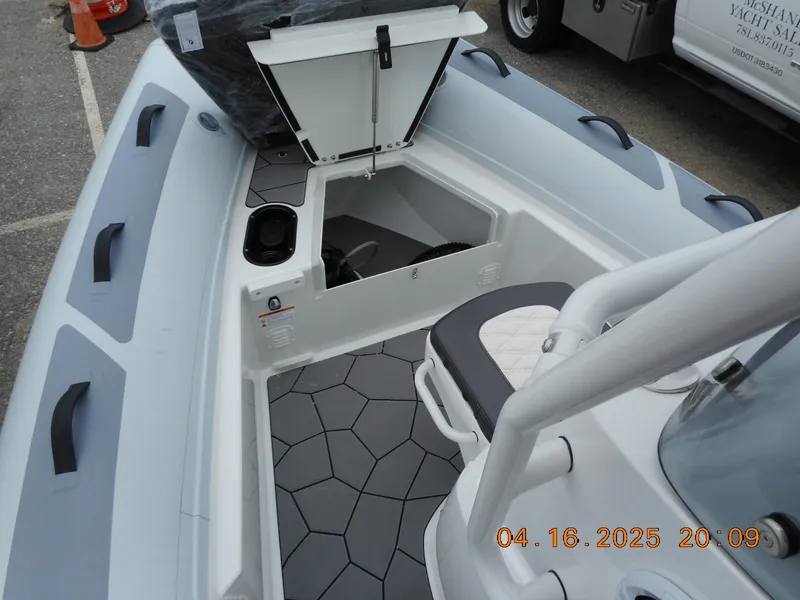 Slide: The Image of 2025 Highfield Sport 560 boat interior with open storage compartment and modern seating. - 19
