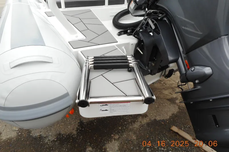 Slide: The Image of 2025 Highfield Sport 560 boat with ladder and motor, docked on a textured surface. - 23