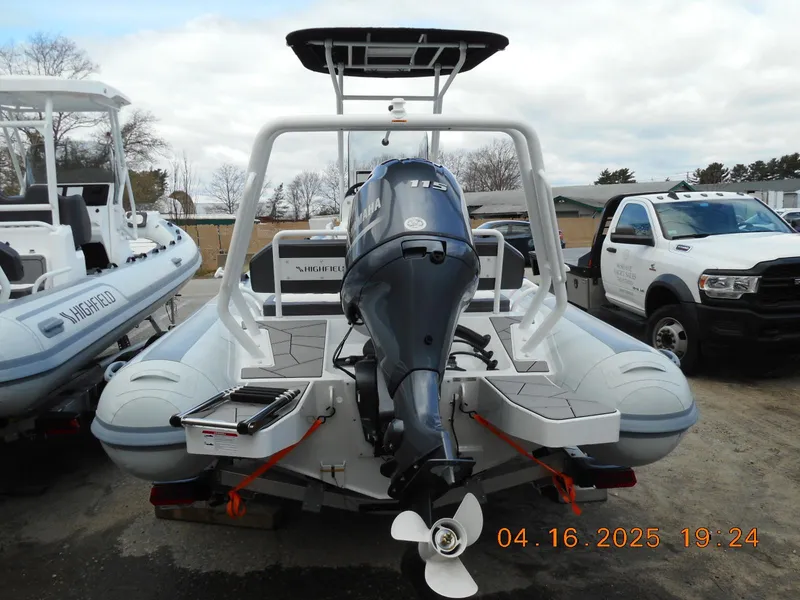Slide: The Image of 2025 Highfield Sport 560 boat with outboard motor, parked outdoors. - 5