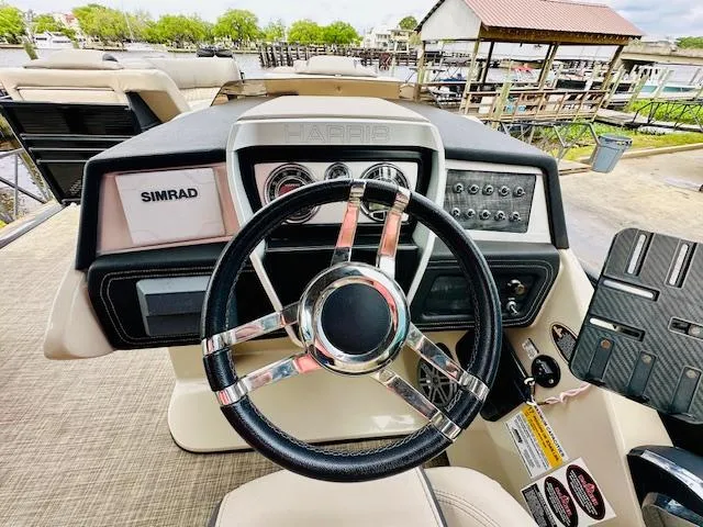 Slide: The Image of 2019 Harris 270 Grand Mariner helm with Simrad display and sleek steering wheel. - 12