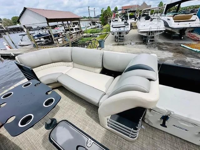 Slide: The Image of 2019 Harris 270 Grand Mariner pontoon boat with spacious seating and cup holders at a marina. - 14